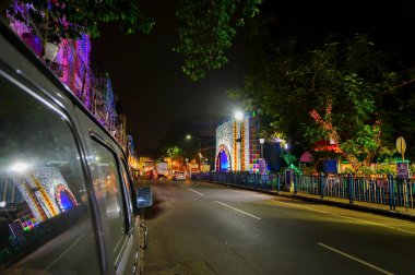 Kolkata, Batı Bengal, Hindistan - 23 Ekim 2020: Gece dekore edilmiş Durga Puja pandalının yansıması, Kolkata caddesinin yanında, araba camında. Hinduizm 'in en büyük festivali dünya çapında kutlandı..