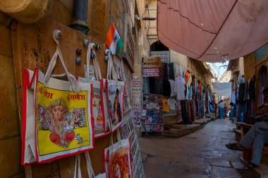 Jaisalmer, Rajasthan, Hindistan - 13 Ekim 2019: Renkli çantalar ve el çantaları sabah saatlerinde Jaisalmer Kalesi 'nin içindeki pazar yerinde satılmak üzere turistlere sunuluyor. UNESCO dünya mirası sahası.