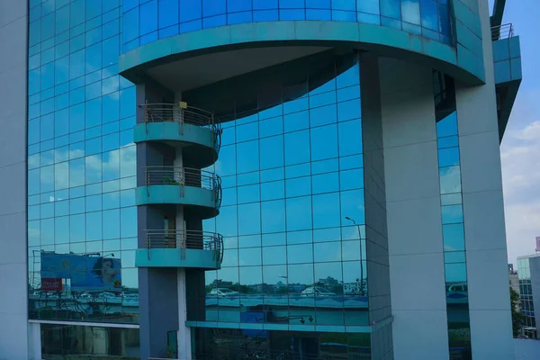 Kolkata, Batı Bengal, Hindistan - 20 Temmuz 2019: Binaların modern mimarisi, cam dış görünüş mavi gökyüzünü, beyaz bulutları ve binaları yansıtıyor.