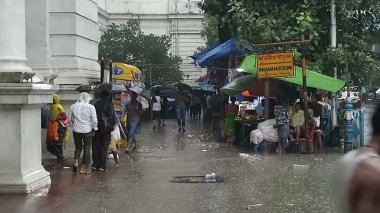 Kolkata, Batı Bengal, Hindistan - 16 Ağustos 2019: Hint müzesi yakınlarındaki su dolu patikada yürüyen yayalar. Kolkata 'da muson yağmurları,