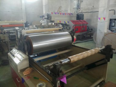 Kolkata, Batı Bengal, Hindistan - 19 Eylül 2019: Beden eğitimi, fabrikanın içinde çalışan polietilen kaplama makinesi. Beden eğitimi, kağıt bardak yapımında kullanılır..