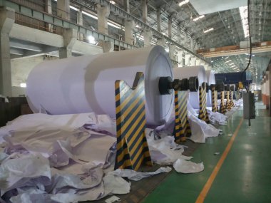 Kolkata, West Bengal, India - 5th May 2021 : White Paper Reels are being manufactured in a paper manufacturing plant. Indian paper industry is growing.