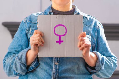 Kadın sembollü karton tabela tutan kadın. Feminist konsept, feminizm, feminist aktivist