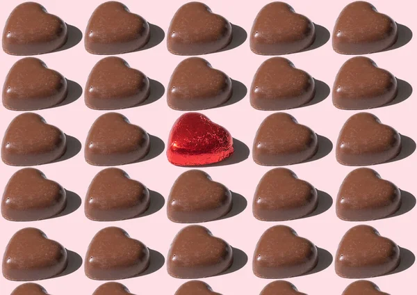 Çikolata kalıpları kalbi şekillendirir, pembe arka plana karşı