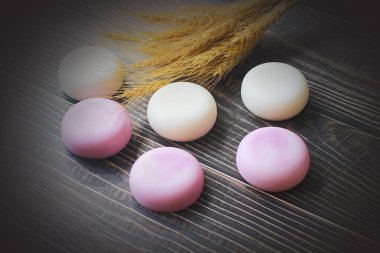 Eski ahşap zemine konmuş el yapımı bitkisel gliserin sabunu, havlular ve diş fırçaları sağlanıyor..