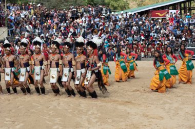 2 Aralık 2016 'da Nagaland Hindistan' da Hornbill festivali sırasında geleneksel kıyafet dansı yapan bir grup naga kabile üyesinin seçici odak noktası.