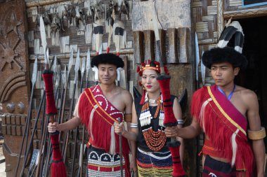 1 Aralık 2016 'da Kohima Nagaland Hindistan' da geleneksel kıyafetlerle geleneksel silahlarla Naga kabilesi erkekleri ve bir Naga kadını