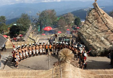 2 Aralık 2016 'da Nagaland Hindistan' da Hornbill festivali sırasında geleneksel kıyafet dansı yapan bir grup naga kabile üyesinin seçici odak noktası.