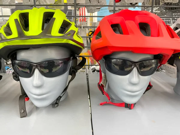 Close up image of two mannequins wearing cycling sports helmet and black sunglasses