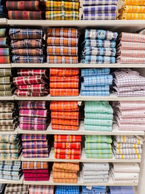 Stacks of colorful checks pattern full sleeves shirts displayed on the shelf of a retail shop in Pune Insia on 9 December 2021