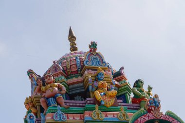 A close-up view of a Hindu temple top with sculptures of Hindu God and Goddess made on it 