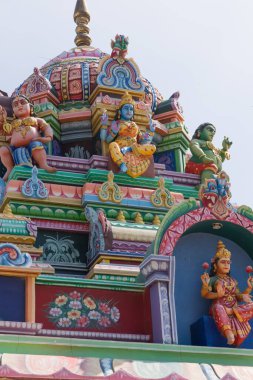 A close-up view of a Hindu temple top with sculptures of Hindu God and Goddess made on it 