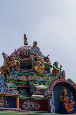 A close-up view of a Hindu temple top with sculptures of Hindu God and Goddess made on it 