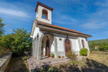 Güzel mavi gökyüzü ve arkasında bulutlar olan bir köyde küçük bir kilise.