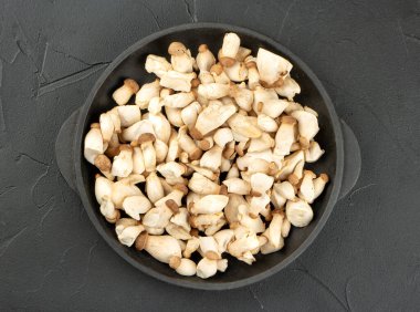 Eringi mantarları kızartılmış tavada, arka planda, üst tarafta.