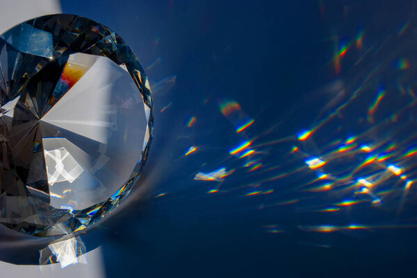 Glass prism in the form of a diamond with polished edges and light spots passing through them