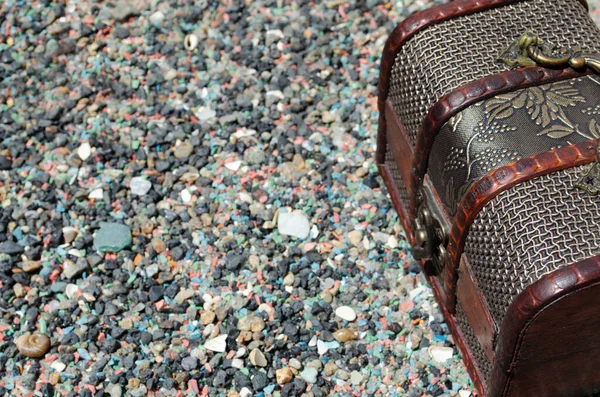 Mücevher kutusu ahşap elementler ve taş zeminde metal bir çerçeve.