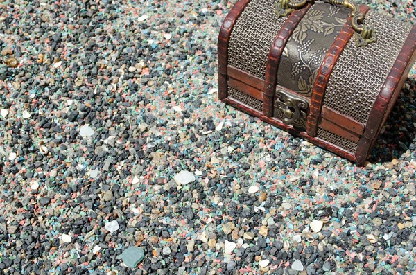 Mücevher kutusu ahşap elementler ve taş zeminde metal bir çerçeve.