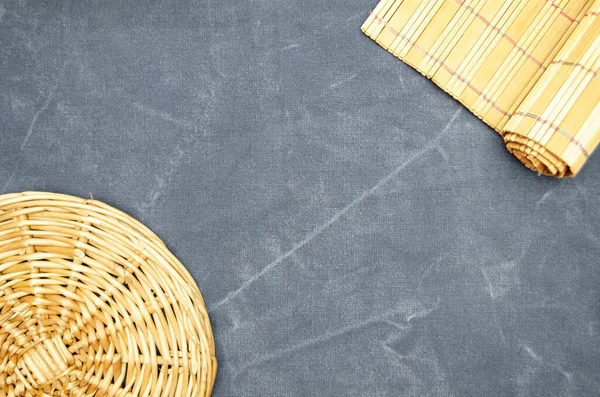 Gri kot pantolon arka planında bambu paspas ve saman tabak