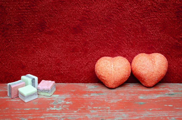Tatlı kalpler kırmızı kumaş ve kırmızı ahşap arka plan Sevgililer Günü