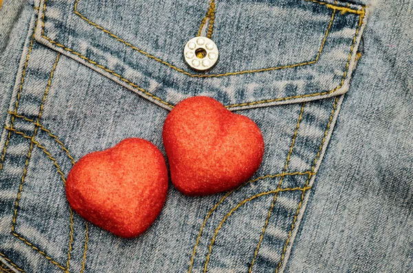 Kot pantolon arka planında iki kırmızı tatlı kalp Sevgililer Günü düz yatıyordu