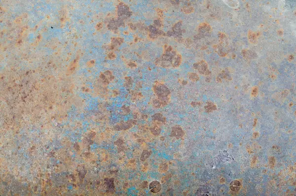 Metal bir arka planda kırmızı pas lekeleri var.