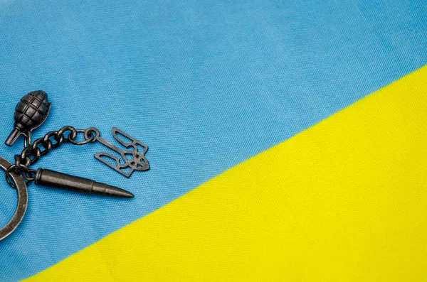 Ukrayna bayrağının arka planında Ukrayna arması olan metal anahtarlık