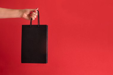 Kara Cuma konsepti. Siyah çanta kırmızı arkaplanda, metin için boşluk var.