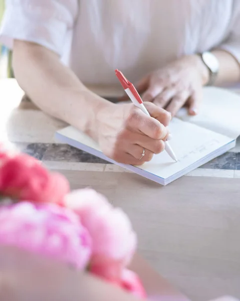Μια Νεαρή Γυναίκα Κρατάει Σημειώσεις Ένα Σημειωματάριο Γράφει Μια Λίστα — Φωτογραφία Αρχείου