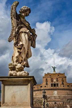 Marble statue of winged angel from the Ponte Sant'Angelo Bridge on the cloudy sky background. Rome, Italy.