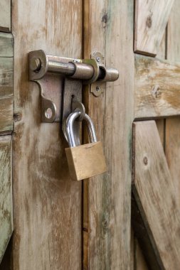 Kırsal ahşap bir kapının pimine asma kilit, metal nesne dokusu, kilitli giriş ve güvenlik kavramı, arka plan