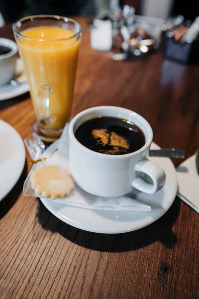 Dřevěný Stůl Snídaní Šálkem Kávy Espresso Smetanou Pomerančovým Džusem Sušenkou — Stock fotografie