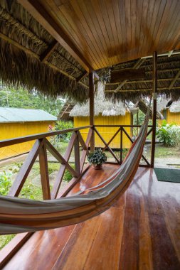 interior of a hotel with a wooden balcony and a hammock to relax, cozy tourist destination, hotel