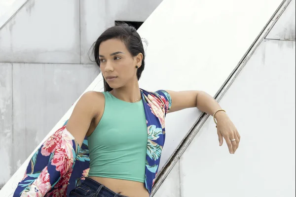 attractive latin woman with short hair having fun posing outside in the city, she wears jeans and colorful kimono in trend, natural model beauty
