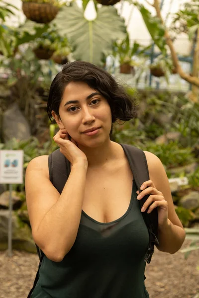 tourist on vacation inside a garden with nature, young latin woman with short hair, natural beauty and lifestyle on vacation