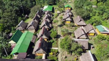 Ormanla çevrili kırsal alan, kulübeleri ve doğası olan mimari, gündüzleri turistik alan, manzara.