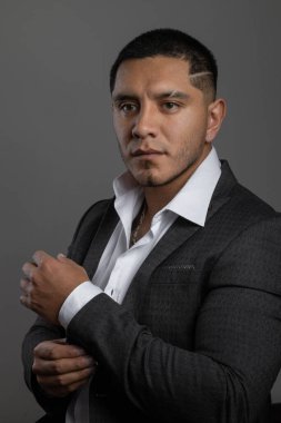 Beyaz gömlek ve takım elbise giyen bir stüdyo resmi kısa saçlı, iş adamı ve modern yaşam tarzı olan genç bir Latin.