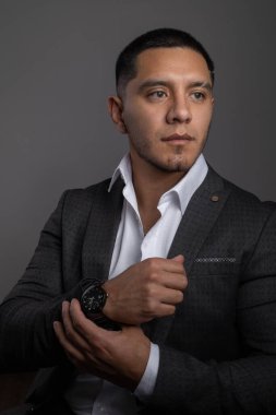 Gömleğinin kolunu tutan kısa saçlı latin genç adam, iş adamı ve modern yaşam tarzı, resmi kıyafetler, zarafet.