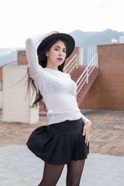 Açık havada poz vermek, şapka, kazak ve etek giymek, Latin kadın güzellik ve gençlik modası, yaşam tarzı