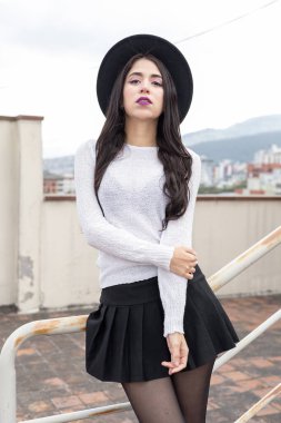 Bir kişi gündüzleri rahat, genç Latin kadın yaşam tarzı günlük kıyafetler giyiyor, manken pozu veriyor.