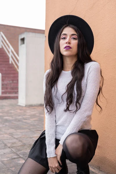 Agachamento Latina Jovem Com Cabelo Ondulado Longo Posando Usa Chapéu — Fotografia de Stock