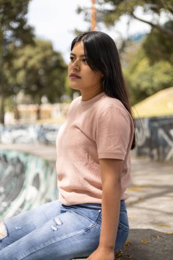 Parkta bir günün tadını çıkaran, doğal güzelliği, uzun saçı ve günlük kıyafetleri olan genç bir kadın, açık havada gençlik hayatı.