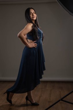 Stüdyoda dans etmek ve topuklu uzun bir balo elbisesi giymek uzun saçlı, hobileri ve yaşam tarzı olan genç bir kadın.