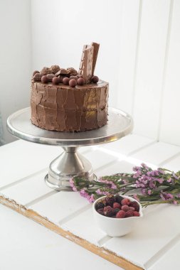 Süs olarak taze meyve ve çiçeklerin yanındaki tabakta çikolatalı pasta, iştah açıcı tatlıları olan pasta dükkanı.