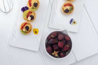 Stüdyoda pasta, servis masasında mutfak gereçleri, tatlı aperatiflerle mutfak duvar kağıtları, böğürtlenler