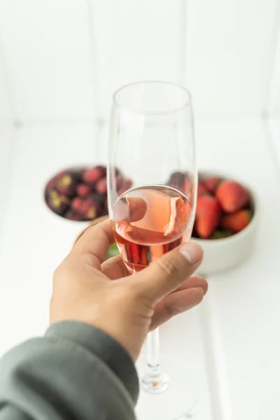 Hålla Ett Glas Kall Champagne Och Bakgrunden Färsk Frukt Jordgubbar — Stockfoto