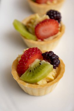 Tatlı, stüdyo dokularının detaylı olduğu duvar kağıdı, tropikal meyvelerle süslenmiş bir tabakta sunulan gurme yemeği.