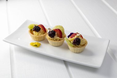 Stüdyo, gurme yemekleri tropikal meyve ve kremayla süslenmiş bir tabakta servis edilir, aperatif olarak pasta.