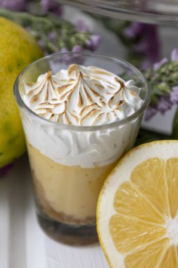 Stüdyoda içinde tatlı olan bir bardak pasta kremalı bir pasta, limonla süslenmiş bir masa, stüdyoda hamur işleri ve meyveler, tatlı yiyecekler.