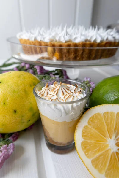 chocolate cake with pastry cream next to a cup with coffee and lemon, pastries and fruits in studio, kitchen